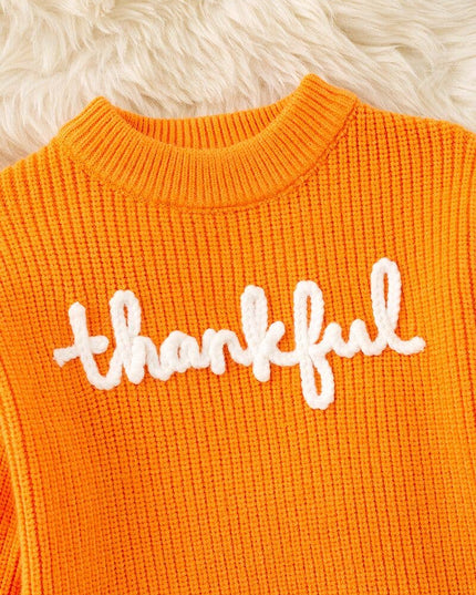 Orange Thankful knit sweater with embroidered flowers on sleeves.