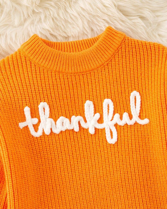 Orange Thankful knit sweater with embroidered flowers on sleeves.