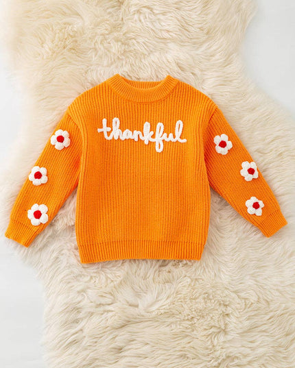 Orange Thankful knit sweater with embroidered flowers on sleeves.