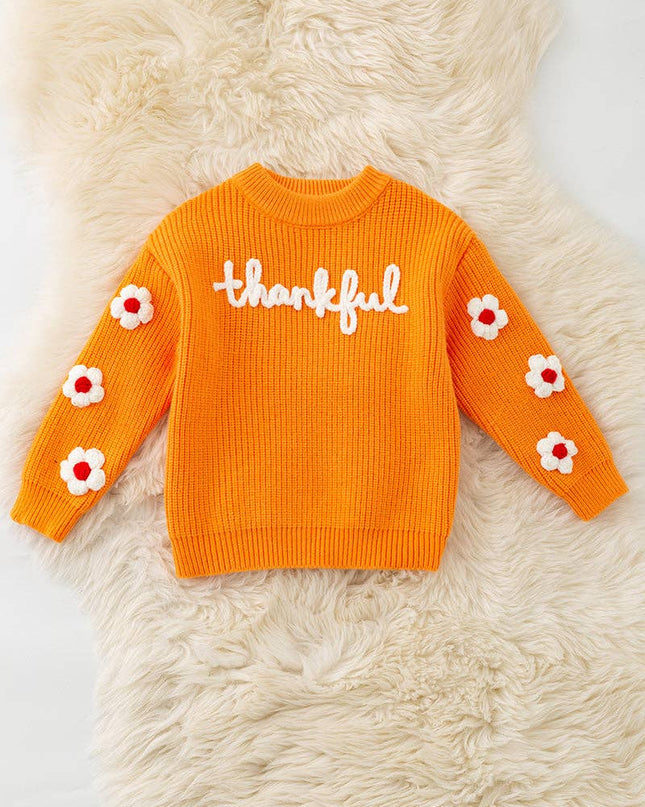 Orange Thankful knit sweater with embroidered flowers on sleeves.
